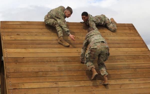 U.S. Army Pfc. Kael Mullins, (left) and Pfc. Travis D. Carter, (right), both signal support specialists with the 534th Signal Company, 4th Special Troops Battalion, 4th Sustainment Brigade, help Pfc. Tamara Borja, (center), a signal support specialist, over an obstacle at Fort Carson, Colo., May 8, 2019.