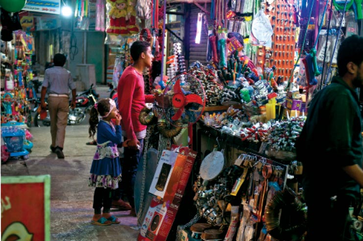 A young man and a girl browse at a market 12 July 2018 in Manbij, Syria. 