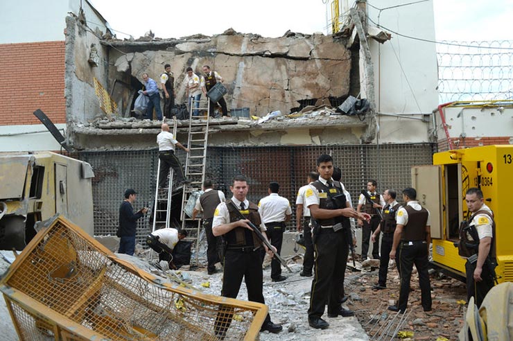 Guards and police inspect a vault that was blown up during an armed robbery of Prosegur