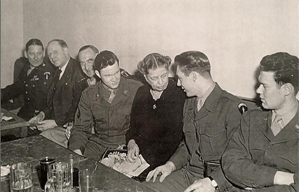 Sgt. Verlan Gunnell (<em>second from right</em>) speaks with Eleanor Roosevelt <em>(third from right</em>) in this photograph from World War II. Also pictured (<em>from left</em>) are Brig. Gen. James Edmunds, administrative officer of the Office of Military Government, United States (OMGUS