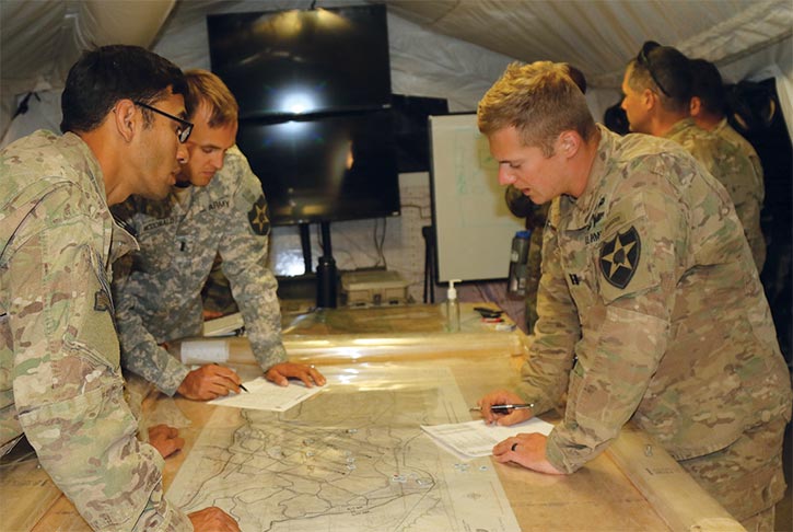 Capt. Wade Redenius (<em>right</em>) discusses the plan for an upcoming mission with 1st Lt. Ross McDonald and 2nd Lt. Tony Eshoo