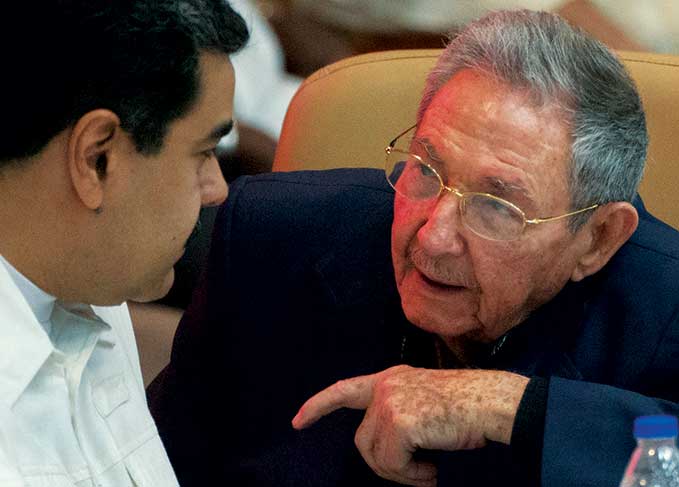 Venezuelan President Nicolás Maduro (<i>left</i>) listens to then Cuban President Raul Castro