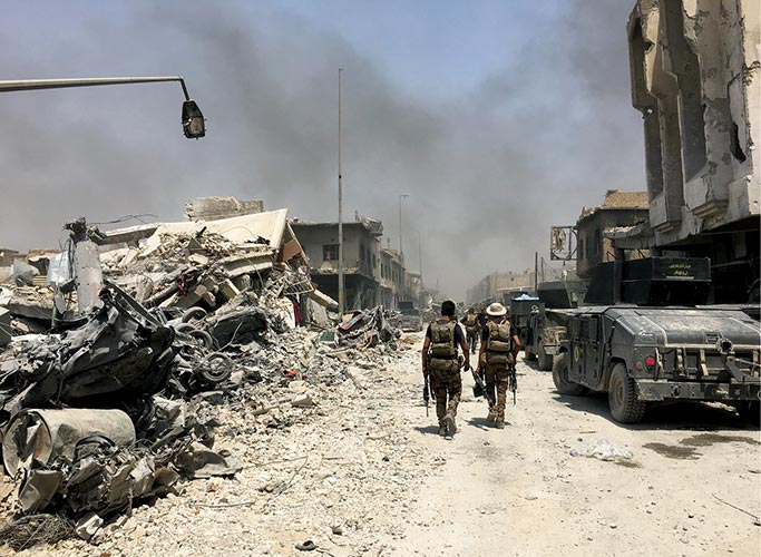 Iraqi special operations forces move through the Old City section of Mosul, Iraq
