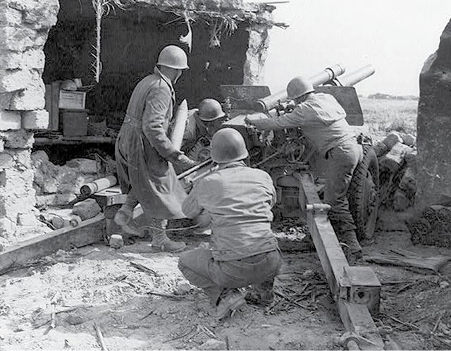 U.S. Army artillery crew in action February 1943 at Kasserine Pass, Tunisia.