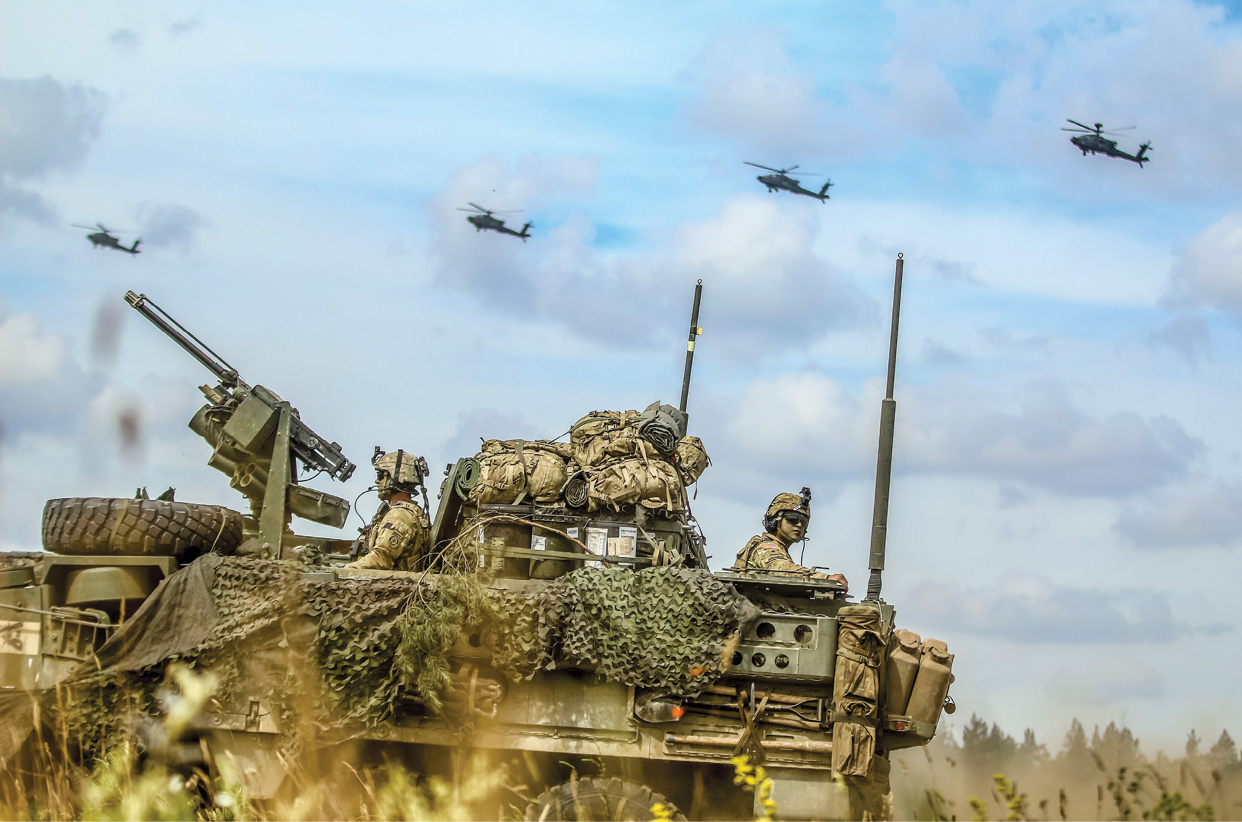 An Interim Armored Vehicle “Stryker” and AH-64 Apache helicopters move to secure an area 15 June 2018 during a lethality demonstration for exercise Puma 2 with Battle Group Poland as part of Saber Strike 18 at Bemowo Piskie Training Area, Poland. The exercise tested allies and partners from nineteen countries on their ability work together to deter aggression in the region and improved each unit’s ability to perform its designated mission. (Photo by Spc. Hubert D. Delany III, U.S. Army)