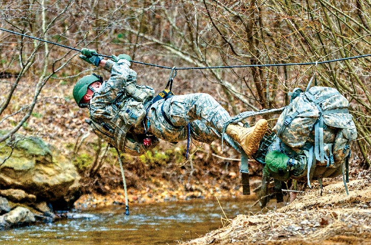 A soldier pulls himself across a rope bridge 21 February 2011 during the Mountain Phase of Ranger School at Camp Merrill