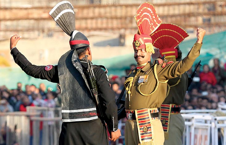 A Pakistani ranger (left) and an Indian soldier gesture to each other during a flag lowering ceremony 9 January 2017 in Lahore