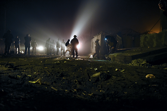 Afghan security forces inspect the site of a suicide car bomb 19 November 2014 at the gate of Green Village compound, a large fortified complex where many international contractors live and work in Kabul, Afghanistan. This was one of many explosions to rock the Afghan capital around that time. (Photo by Shah Marai, Agence France-Presse)