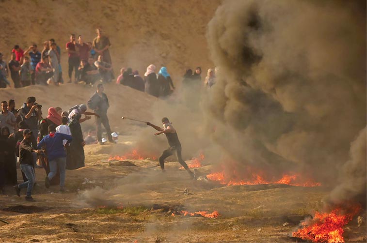Palestinian protesters participate in a violent demonstration 1 June 2018 against Israel’s eleven-year blockade of Gaza and its refusal to allow refugees to return to their villages inside the zone. 