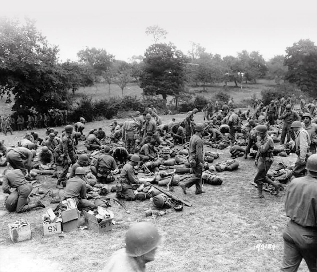 Replacements for the 90th Infantry Division ready their packs for life on the front lines July 1944 in Prétot-Sainte-Suzanne, France.