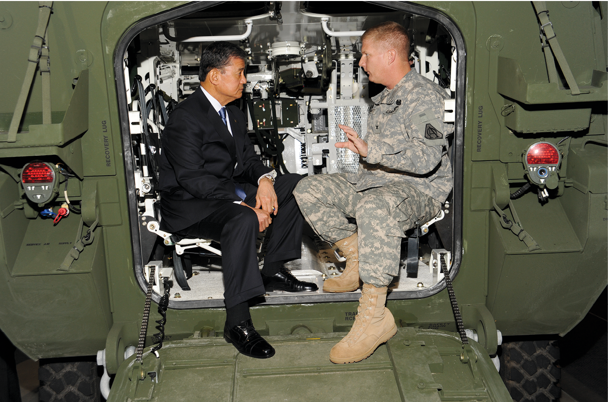 Retired Gen. Eric K. Shinseki sits inside a Stryker vehicle 5 May 2011 in Sterling Heights, Michigan, and talks with Col. Robert Schumitz, Stryker project manager, about how the vehicle was first fielded by the U.S. Army. As the authors explain, Shinseki worked with then Secretary of the Army Louis Caldera to ensure the Army’s fielding of the Stryker brigade combat team, considered a successful enterprise-level action. (Photo courtesy of Detroit Arsenal Media Services, U.S. Army)