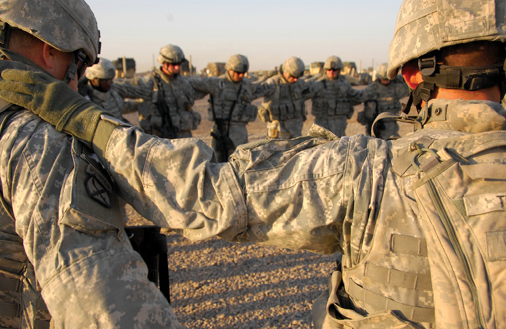Soldiers from Alpha Battery, 2nd Battalion, 32nd Field Artillery Regiment join to say a prayer before a mission 29 October 2007 at Forward Operating Base Liberty, Iraq. (Photo by Spc. Charles W. Gill, U.S. Army)