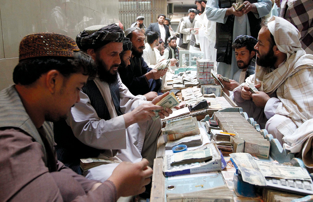Afghan dealers exchange currency at a money market 11 November 2012 in Kandahar Province, Afghanistan. Such money markets frequently employ hawala, a traditional system of money transfer used extensively in the Middle East and Africa, to move large amounts of money without transferring them either physically or via wire transfer through a formal institution such as a bank. Under the system, an agent receives money from a customer at one location, who then—for a small fee—instructs an agent at a different location to pay that amount to a designated recipient of funds at a different location. Since the system is relatively informal, consummated by a handshake, it is difficult to monitor. As a result, it is often used by terrorists or other nefarious agents to transfer funds globally. (Photo by Ahmad Nadeem, Reuters)