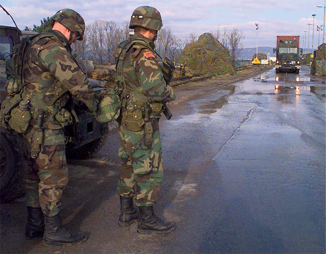 Sgt. Blair Smolar (left) adjusts the pack of fellow Virginia National Guard soldier Sgt. Ovidio Perez 29 December 1997 in Bosanki Brod, Bosnia and Herzegovina.