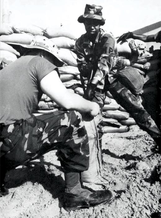 Spc. Wanda E. Belin, 200th Military Police Company, Maryland Army National Guard, shovels sand into a bag to fortify the base camp in Eastern Saudi Arabia in 1990 during Operation Desert Shield.