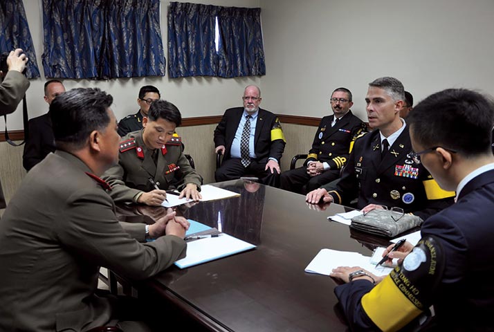 Cel James M. Minnich, do Exército dos EUA (segundo a partir da direita), Secretário da Comissão Militar de Armistício do Comando das Nações Unidas, dirige-se ao Cel Pak Ki-yong