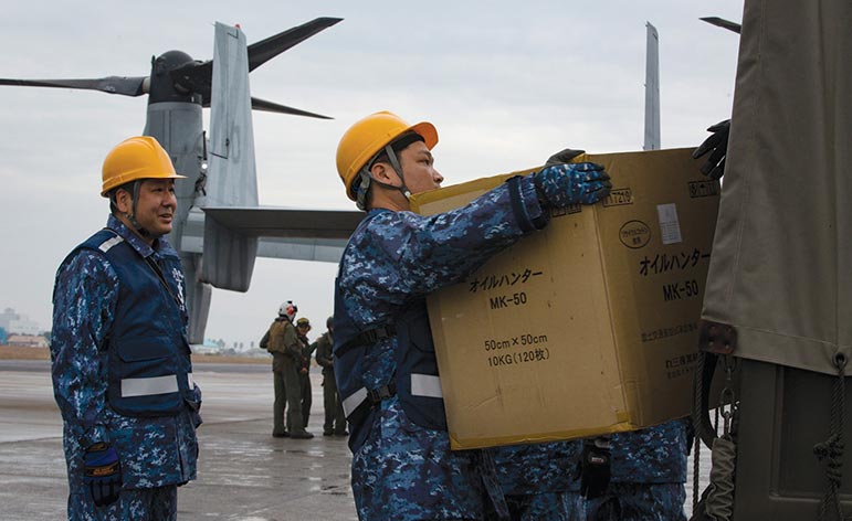 Integrantes da Força Marítima de Autodefesa do Japão retiram suprimentos humanitários simulados