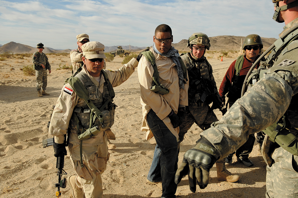 Militares norte-americanos simulam assessoramento a soldados iraquianos na condução de possíveis terroristas, durante treinamento no Centro Nacional de Adestramento, no Forte Irwin, Califórnia, 09 Nov 09. (Força Aérea dos EUA, Cb Asha McMakin)