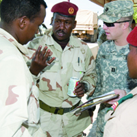 Um capitão do Exército dos EUA, oficial do estado-maior da Força-Tarefa Conjunta-Chifre da África, e um militar do Exército de Djibuti conversam depois de uma cerimônia de formatura para os militares djibutianos que concluíram o curso de adestramento em contraterrorismo, Arta, Djibouti, 27 Nov 06. (Marinha dos EUA, Suboficial Philip A. Fortnam)