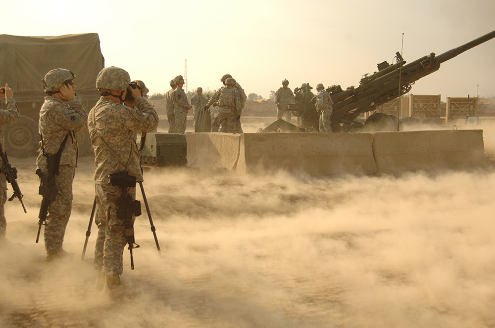 Integrantes do 145º Destacamento de Comunicação Social registram imagens de uma tropa de artilharia da 3ª Brigada de Combate ajustando os fogos de uma peça M777 howitzer, Base de Operações Avançadas Warhorse, na Província de Diyala, Iraque, 8 Dez 09.