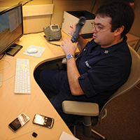 Integrante da Guarda Costeira dos EUA utiliza sistema de monitoramento das mídias sociais para auxiliar em resgates e evacuações médicas. (Marinha dos EUA, Walter Shinn)
