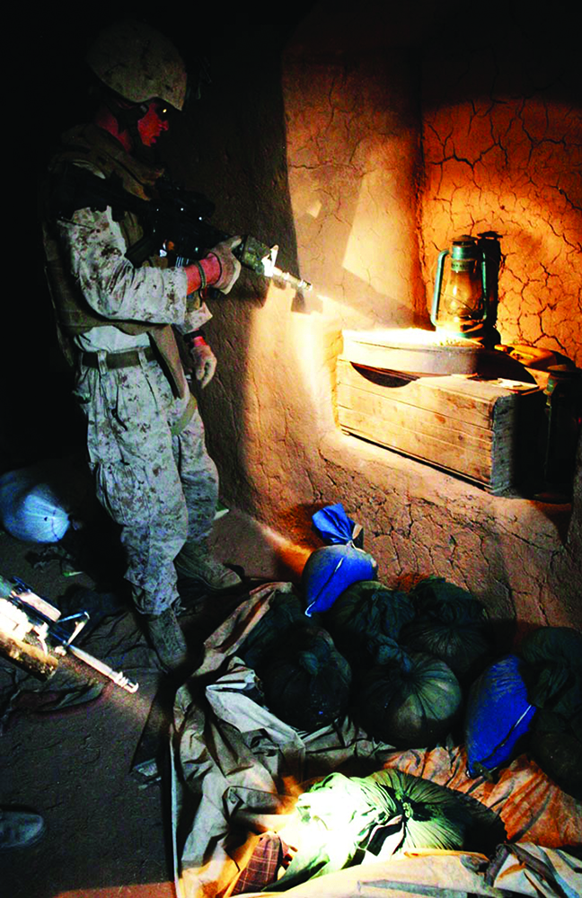 Fuzileiros navais vasculham um complexo para combater o narcotráfico, que talvez financie a insurgência em uma aldeia na Província de Helmand, no Afeganistão, 30 Jul 09. (Departamento de Defesa, Cb Caleb Gomez, CFN dos EUA)