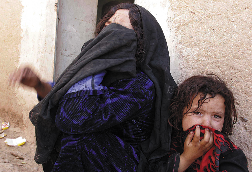 Mulher afegã e sua filha choram a morte de um parente, provocada por ataque aéreo em Azizabad, aldeia no Distrito de Shindand, Província de Herat, Afeganistão, 23 Ago 08. (Foto AP/Fraidoon Pooyaa, File)