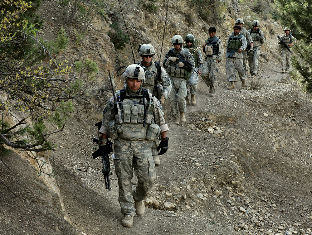Soldados americanos e policiais de fronteira afegãos caminham ao longo de uma trilha de montanha durante uma patrulha na Província de Paktiya , no Afeganistão, 13 de outubro de 2009. (Exército dos EUA, Sgt Andrew Smith)