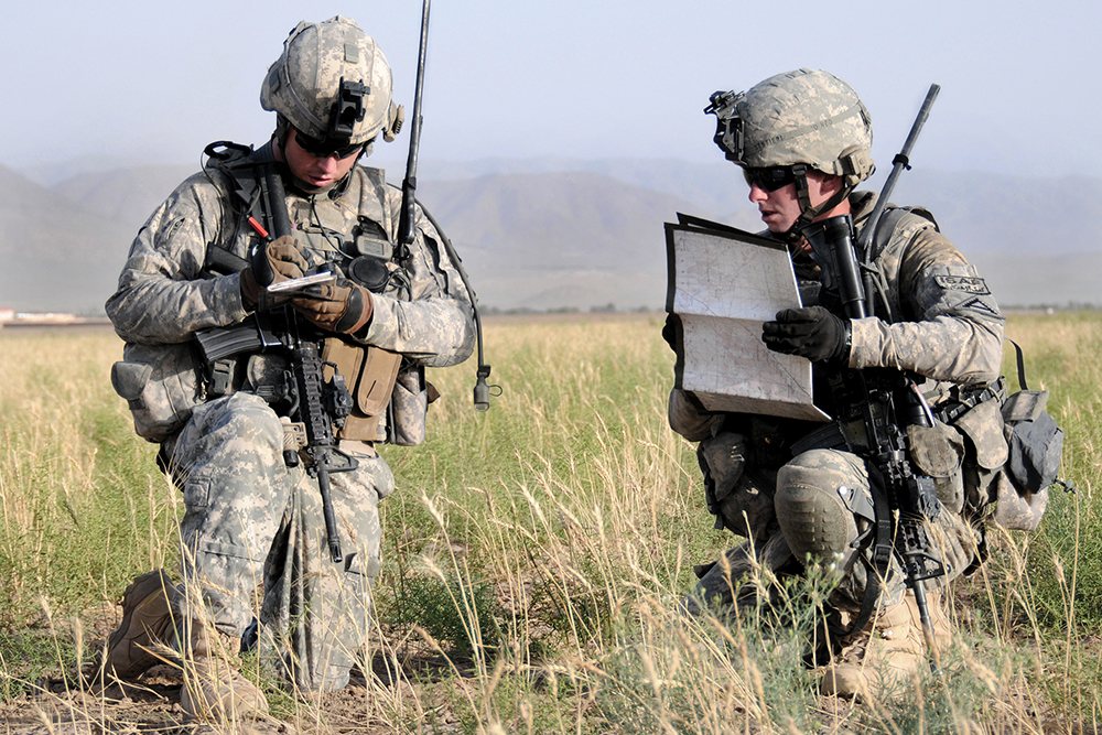 Dois militares patrulham em busca de um caché de armas nas proximidades do posto avançado de combate de Sangar, na Província de Zabul, Afeganistão, 27 Jun 10. (Exército dos EUA, Cb Eric Cabral)