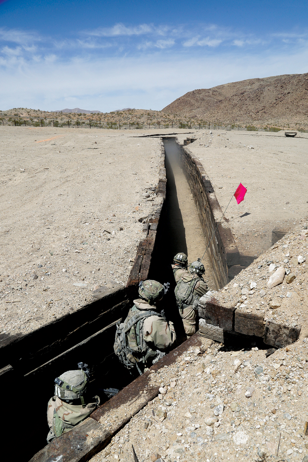 Militares da 1a Brigada de Combate, 2a Divisão de Infantaria, limpam uma trincheira durante o Ciclo de Adestramento 18-06 de Ação Decisiva, no Centro Nacional de Treinamento, em Fort Irwin, Califórnia, 18 Abr 18. Os rodízios no CNT garantem que as unidades permaneçam versáteis, aptas para uma pronta-resposta e permanentemente disponíveis para contingências atuais e futuras. (Cb Daniel Parrott, Grupo de Operações, CNT, Exército dos EUA)