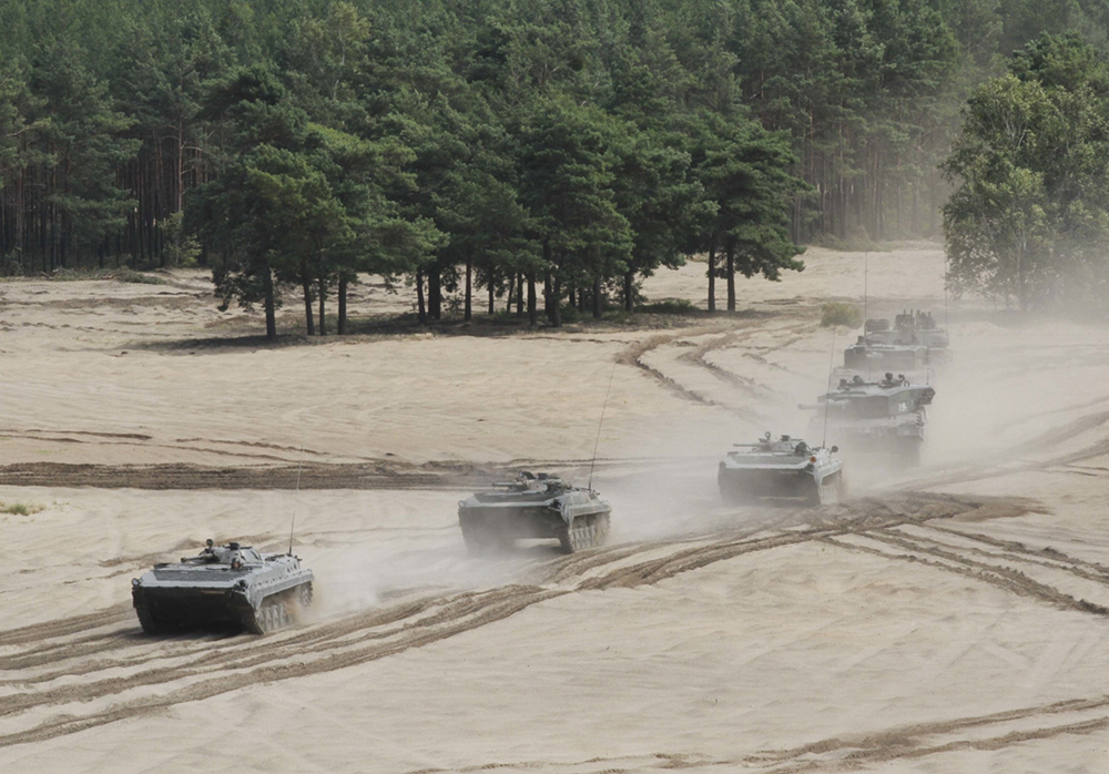 Tripulações de carros de combate designadas à 11a Divisão de Cavalaria Blindada Lubuska chegam à posição para fornecer apoio de fogo aos soldados do 3o Batalhão de Armas Combinadas, 69o Regimento Blindado, 3a Divisão de Infantaria, durante um exercício de tiro real, em Trzebien, Polônia, 19 Jul 16. O exercício fomentou interoperabilidade entre as forças norte-americanas e polonesas como parte da Operação Atlantic Resolve, um esforço liderado pelos EUA no Leste Europeu para demonstrar o comprometimento dos EUA com a segurança coletiva da OTAN e com a paz duradoura e estabilização na região. (Sgt Lauren Harrah, Exército dos EUA)