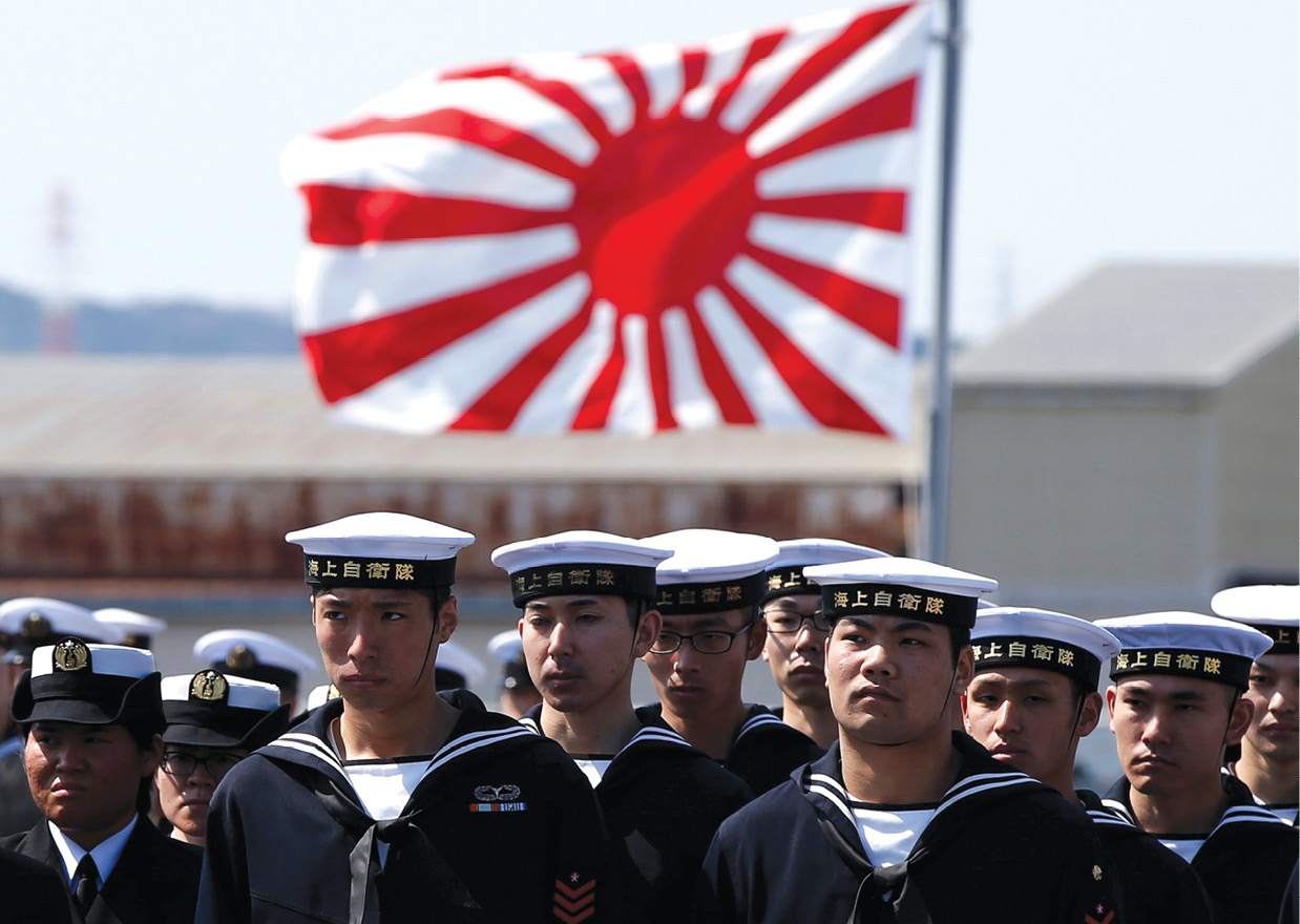 Los miembros de la tripulación del portahelicópteros DDH-184 Kaga de la clase Izumo parados enfrente de la bandera marítima de Japón el 22 de marzo de 2017 durante una ceremonia de entrega por parte de la corporación de construcción naval Japan Marine United a la Fuerza Marítima de Autodefensa de Japón (JMSDF) en Yokohama, Japón. (Foto: Toru Hanai, Reuters)