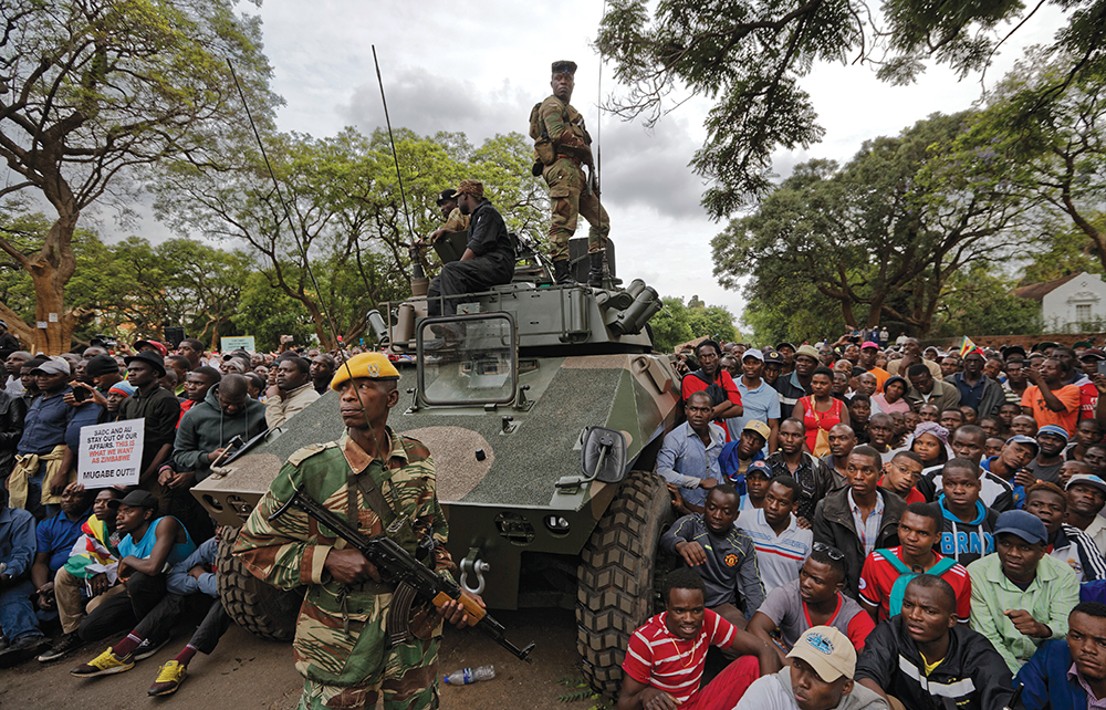 Soldados de guardia mientras manifestantes se reúnen en el camino a la Casa Estatal en Harare, Zimbabue, 18 de noviembre de 2017. Los manifestantes, con el apoyo de las fuerzas armadas, marcharon a través de la capital de Zimbabue para exigir la salida del presidente Robert Mugabe, uno de los últimos líderes de liberación en África, después de casi cuatro décadas en el poder. (Foto: Associated Press, Ben Curtis)