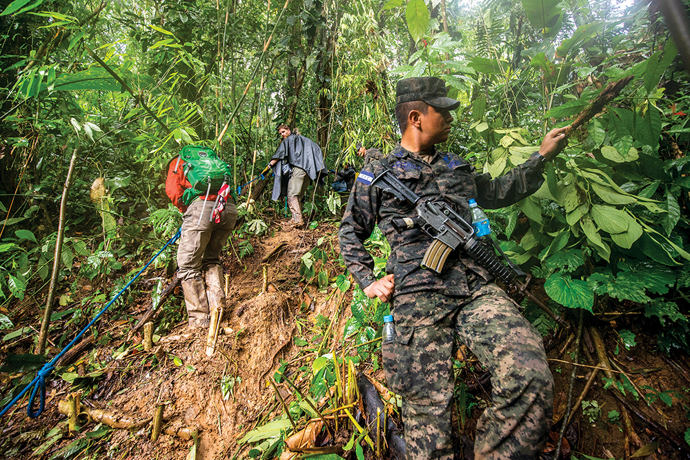 Tropas hondureñas vigilando a un equipo de expedición que buscan las ruinas de una ciudad precolombina en la selva en la Costa de los Mosquitos, Honduras, 22 de febrero de 2015. Tres de las cinco brigadas hondureñas tienen la misión de proteger los sitios arqueológicos en la nación. (Foto: Dave Yoder a través de Alamy photo)