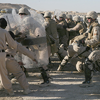 Integrantes del Cuerpo de Infantería de Marina de EUA participan en entrenamiento antidisturbios en la base aérea de Al Asad en Irak, 23 de diciembre de 2007. En el entrenamiento, los participantes aprenden a neutralizar manifestantes agresivos con el uso de tácticas no letales en caso de una manifestación en la base.