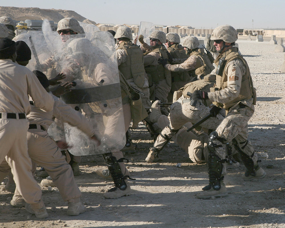 Integrantes del Cuerpo de Infantería de Marina de EUA participan en entrenamiento antidisturbios en la base aérea de Al Asad en Irak, 23 de diciembre de 2007. En el entrenamiento, los participantes aprenden a neutralizar manifestantes agresivos con el uso de tácticas no letales en caso de una manifestación en la base.