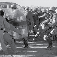 Integrantes del Cuerpo de Infantería de Marina de EUA participan en entrenamiento antidisturbios en la base aérea de Al Asad en Irak, 23 de diciembre de 2007. En el entrenamiento, los participantes aprenden a neutralizar manifestantes agresivos con el uso de tácticas no letales en caso de una manifestación en la base.