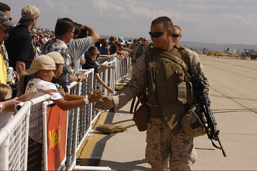 Invitados saludan a los Marines durante el espectáculo aéreo anual patrocinado por los Servicios Comunitarios del Cuerpo de Infantería de Marina de EUA, en la Estación Aérea del Cuerpo de Infantería de Marina en Miramar, estado de California, 2 de octubre de 2010.