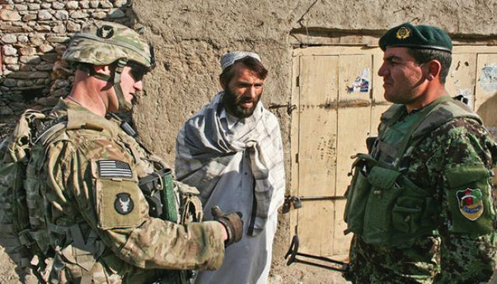 El teniente primero John Dundee (izquierda), un jefe de pelotón en la Compañía A, 1er Batallón, 133o Regimiento de Infantería del Ejército de EUA y el teniente Rastum (derecha) de la 1a Compañía, 1er Batallón, 201o Regimiento del Ejército Nacional de Afganistán hablan con un civil en Ghaziabad, Afganistán, 26 de diciembre de 2010. (Foto: Sgto. 2o Ryan C. Matson, Fuerza de Tarea Red Bulls)