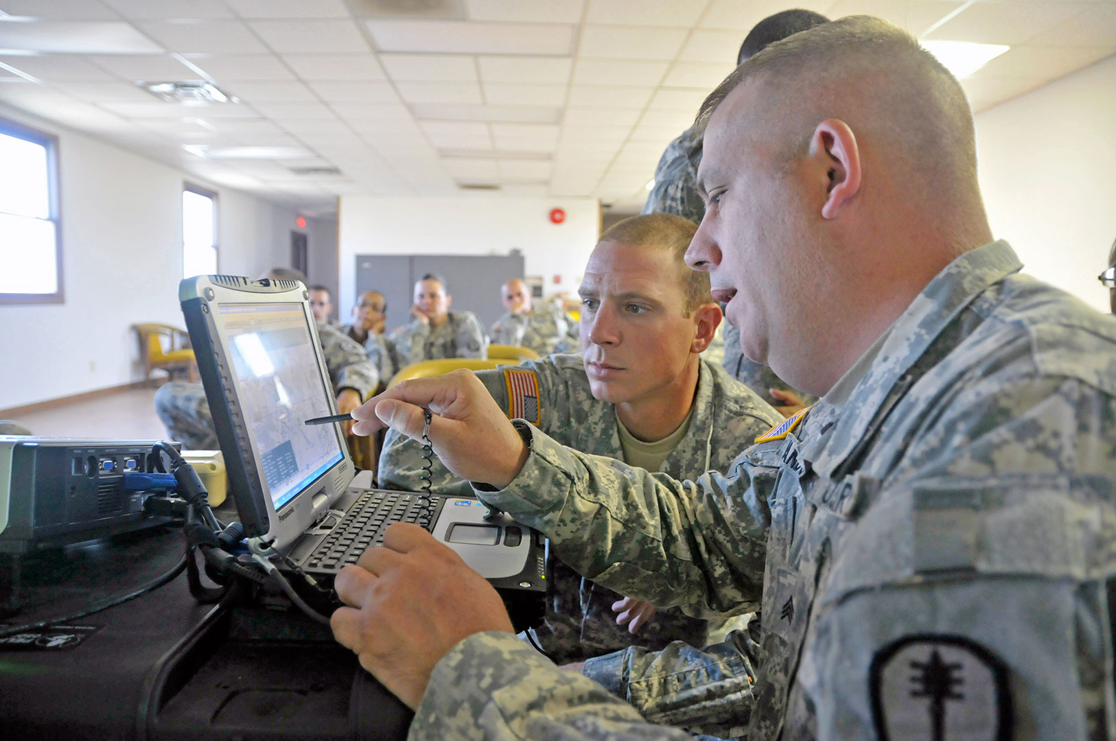 Sgt. Brian Randolph of the 346th Military Police Company at Fort Riley, Kan., demonstrates to a soldier of the 317th Military Police Battalion how he operates a Raven B unmanned aerial vehicle in flight July 25, 2012. While service members who operate and support remotely piloted aircraft or operate in cyberspace are a critical part of the military’s mission, Department of Defense officials have decided to eliminate the Distinguished Warfare Medal intended to honor them.