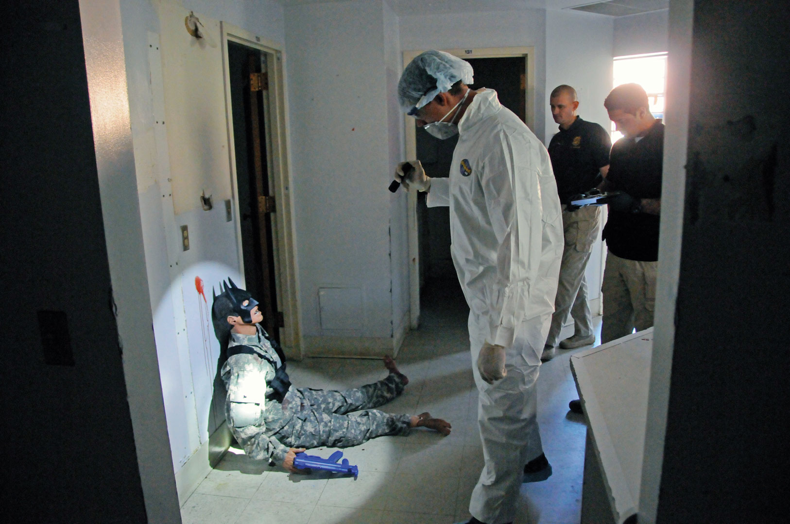 First Sgt. Marvin “Chad” Marlow (background), the first sergeant of the Washington CID Battalion, guides a special agent as he inspects a masked mannequin that represented a suspected hostage-taker during training in October. (Photo by Michael L. Lewis)