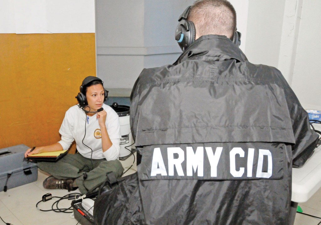 As part of the training scenario that served as a precursor to the mock crime scene, Chief Warrant Officer 2 Jennifer Harris, a special agent of the Washington CID Battalion and a former NCO, talks with a suspected hostage-taker. (Photo by Michael L. Lewis)