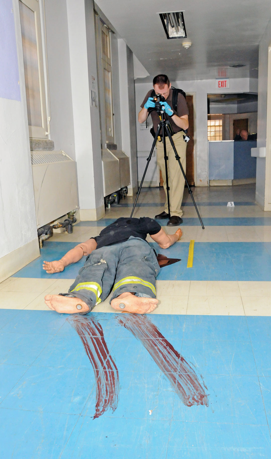 Spc. Timothy Wheeler, a special agent from the Fort Meade, Md., CID Office, takes photos of a mock victim during the crime scene training. (Photo by Michael L. Lewis)