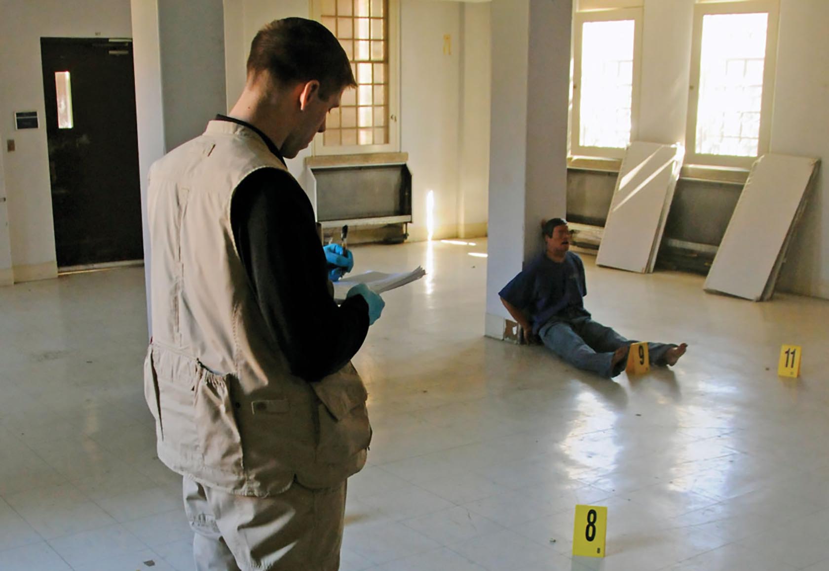 Sgt. Tim Barnes, a special agent at the Fort Belvoir, Va., CID Office, a part of the Washington CID Battalion, makes notes regarding a mock crime scene at an abandoned hospital in Washington, D.C., in October. (Photo by Michael L. Lewis)