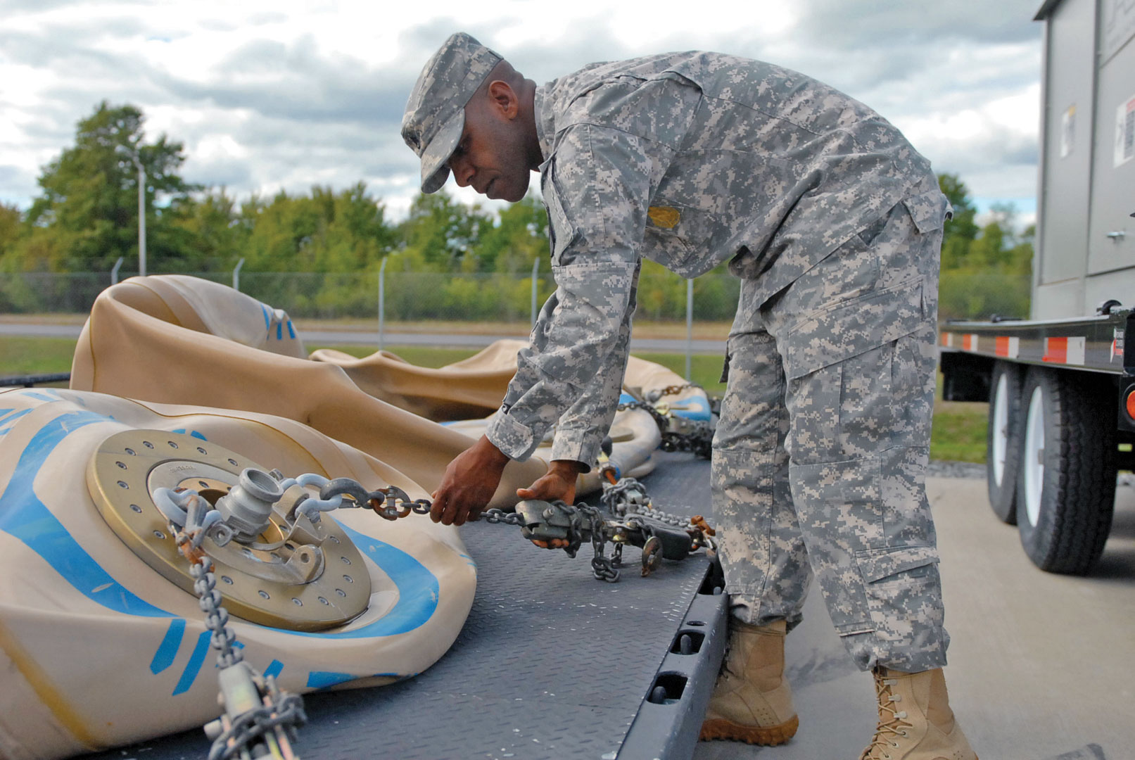 Staff Sgt. Andrew Dugger, a water treatment specialist assigned to A Company, 210th Brigade Support Battalion, 2nd Brigade Combat Team, 10th Mountain Division, inspects the tie down chains for potable water blivets Sept. 10 at Fort Drum, N.Y. (Photo by Spc. Candace Foster)