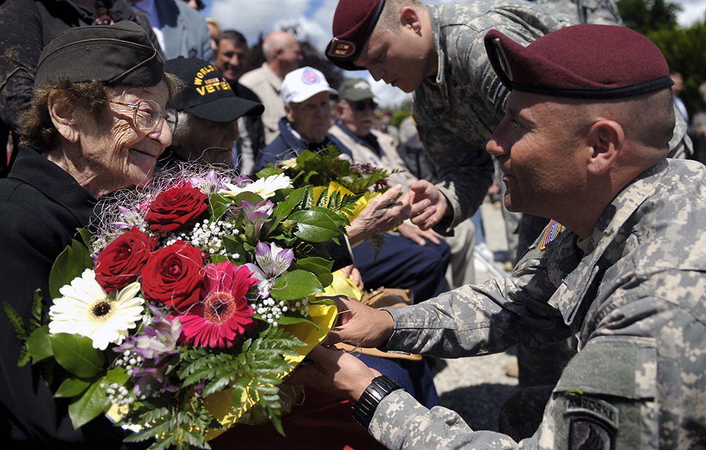 Ellan Levitsky-Orkin, a Delaware native who served as a U.S. Army nurse in Normandy during World War II, speaks with a U.S. Army paratrooper during a ceremony to honor their service in Bolleville, France, June 4, 2014. The event was one of several commemorations of the 70th Anniversary of D-Day operations conducted by Allied forces during World War II June 5-6, 1944. Over 650 U.S. military personnel have joined troops from several NATO nations to participate in ceremonies to honor the events at the invitation of the French government. (Photo by Staff Sgt. Sara Keller)