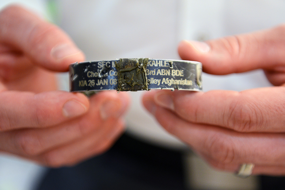 Pitts holds a bracelet he wears that commemorates the late Sgt. 1st Class Matthew Kahler, a former platoon sergeant of 2nd platoon, which is taped over another bracelet (not visible) that commemorates the fallen of 1st Platoon, “Chosen” Company, who were killed in a Nov. 9, 2007, ambush. The bracelets prevented shrapnel from penetrating Pitts’ wrist. (Photo by Lisa Ferdinando)