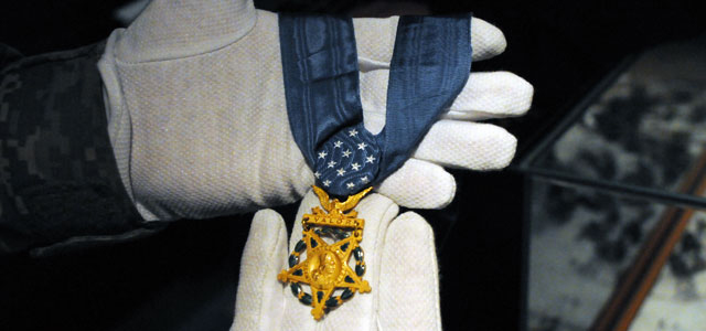 Sgt. 1st Class Carlos Peña holds the Medal of Honor received by Sgt. 1st Class William S. Sitman.