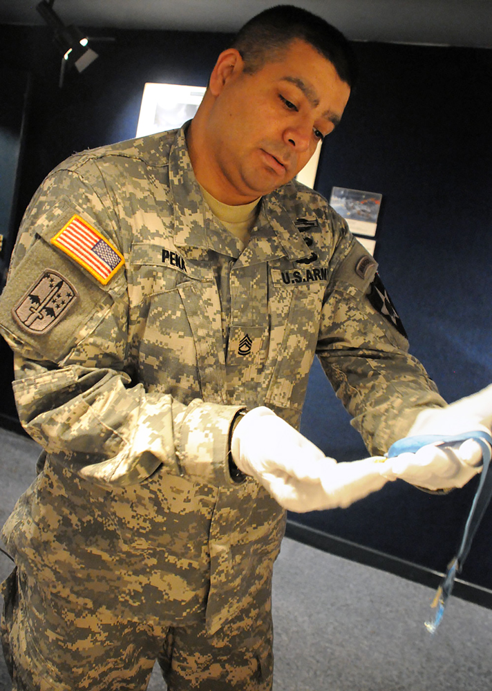 When Sgt. 1st Class Carlos Peña toured the 2nd Infantry Division Museum, he was allowed to hold the Medal of Honor received by Sgt. 1st Class William S. Sitman. (Photo by Jonathan (Jay) Koester / NCO Journal)