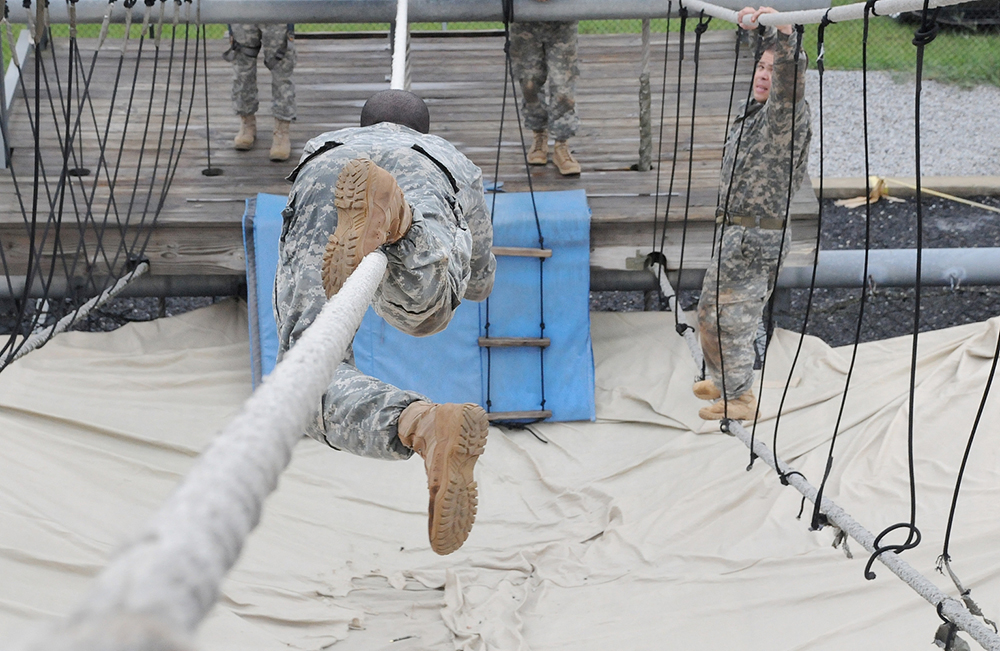 As Sgt. 1st Class Charles Sheffield of B Company, 309th Military Intelligence Battalion, 111th MI Brigade, at Fort Huachuca, Ariz., makes his way down a rope obstacle on the Victory Tower as Sgt. 1st Class Ryan Moreno of B Company, 84th Chemical Battalion, at Fort Leonard Wood, Mo., makes his way up Monday. Both Sheffield and Moreno are competing to be AIT Platoon Sergeant of the Year.